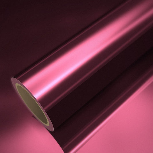 Rotolo di pellicola cromata rosa rossastro su un foglio della stessa pellicola
