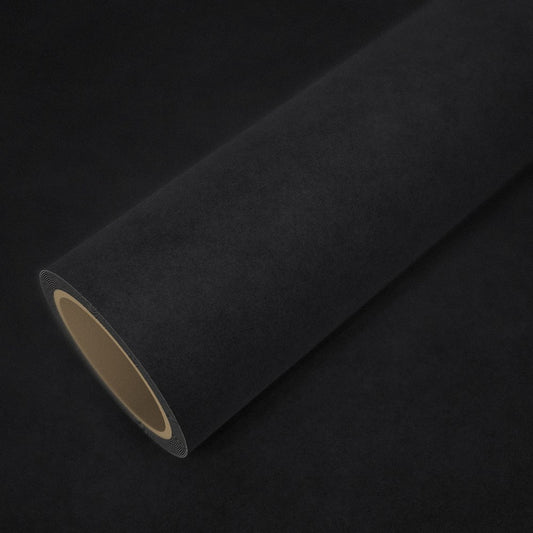 Rotolo di pellicola effetto alcantara nero su un foglio della stessa pellicola